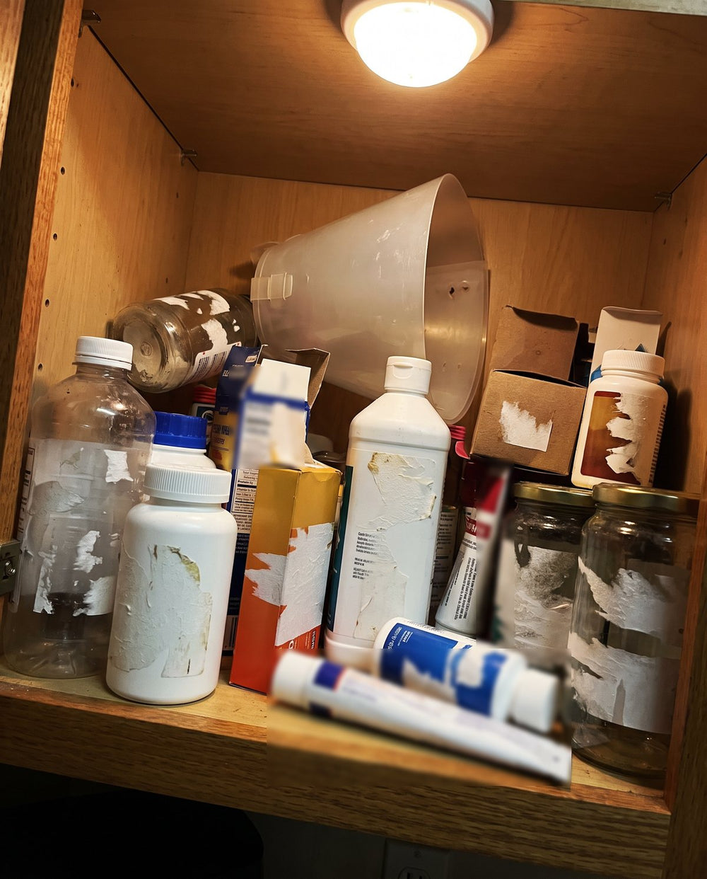 Un gabinete lleno de shampoos a medio usar, sprays, pastillas y un cono